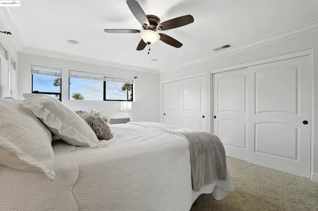 a spacious bedroom with a bed and a ceiling fan