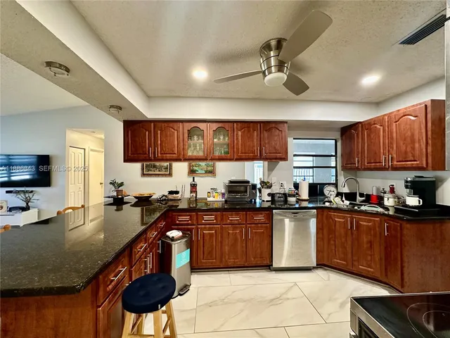 a kitchen with stainless steel appliances granite countertop a sink a counter top space and cabinets