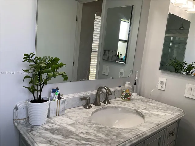 a bathroom with a granite countertop toilet sink and mirror