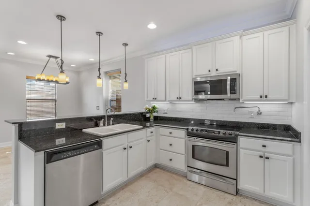 a kitchen with stainless steel appliances granite countertop a sink a stove and a microwave