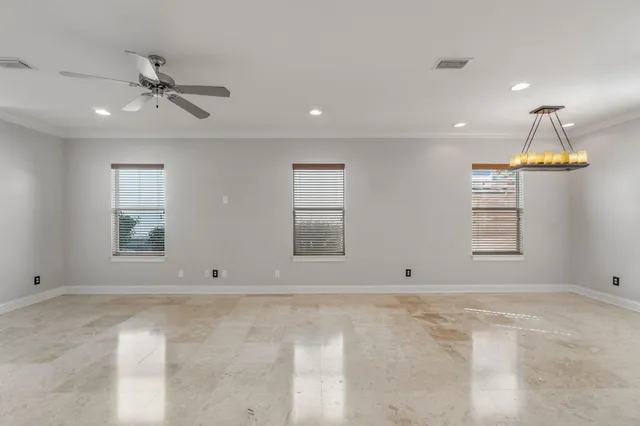 an empty room with window and ceiling fan