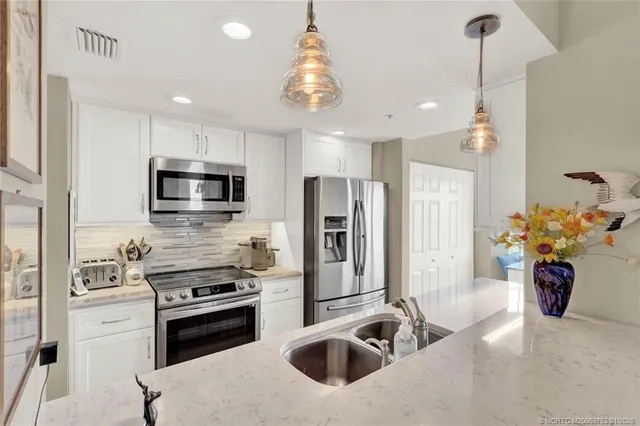 a kitchen with stainless steel appliances sink stove top oven and cabinets