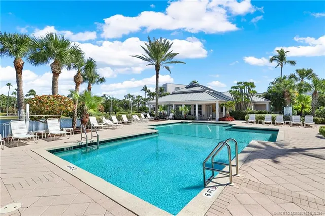 a view of a house with pool and chairs