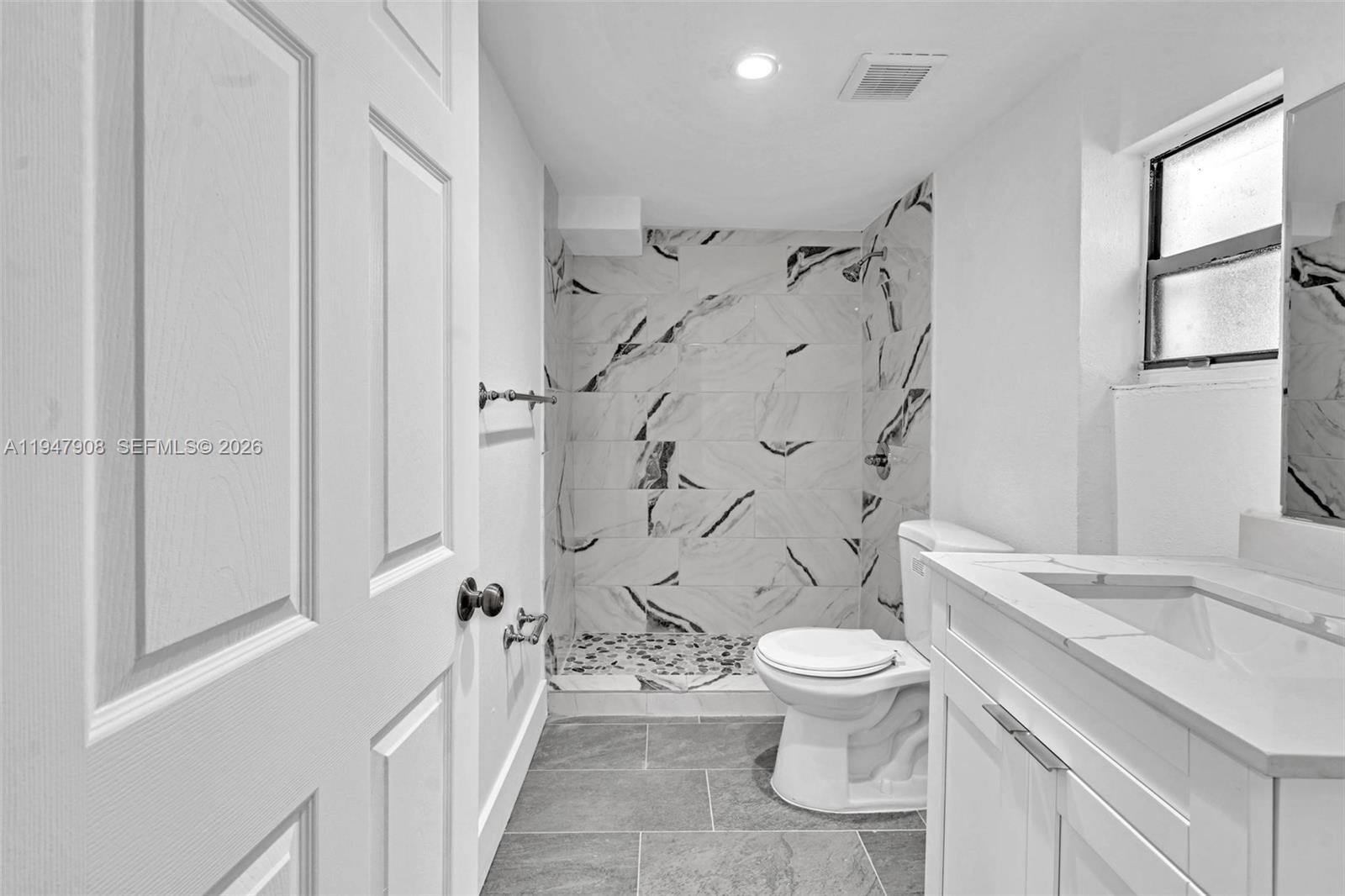 2636 Southwest 29th Court Miami, FL 33133 - Photo 22 of 33 a bathroom with a granite countertop sink toilet and shower