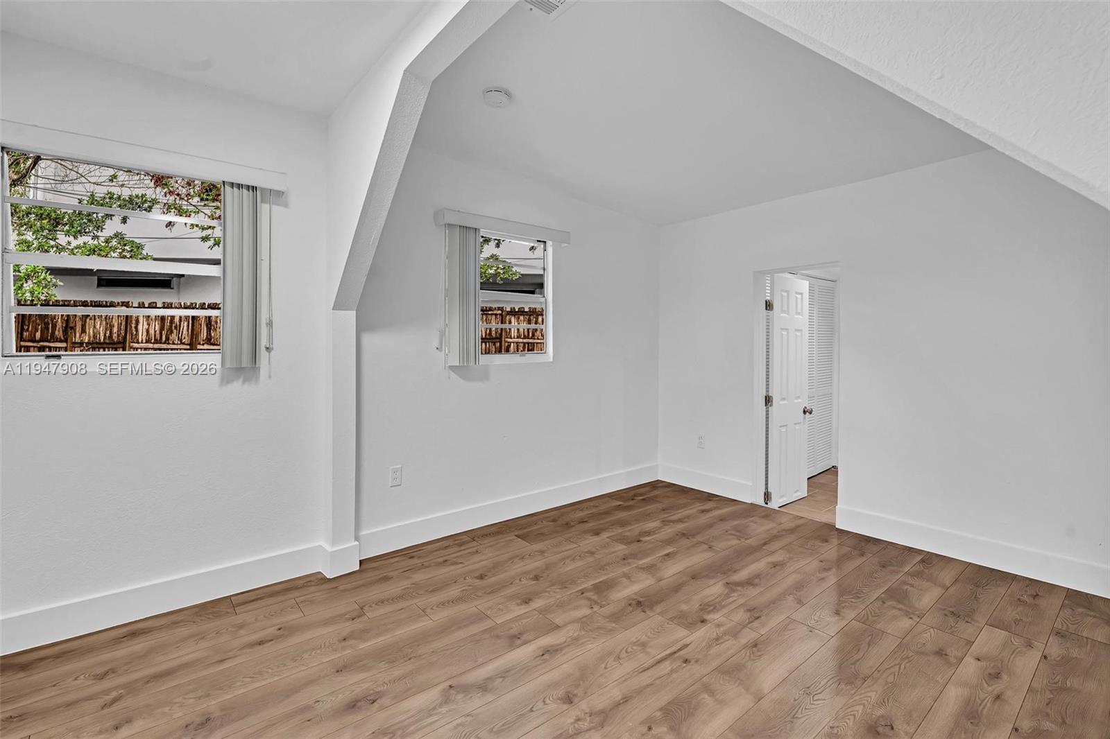 2636 Southwest 29th Court Miami, FL 33133 - Photo 27 of 33 a view of an empty room with wooden floor and window