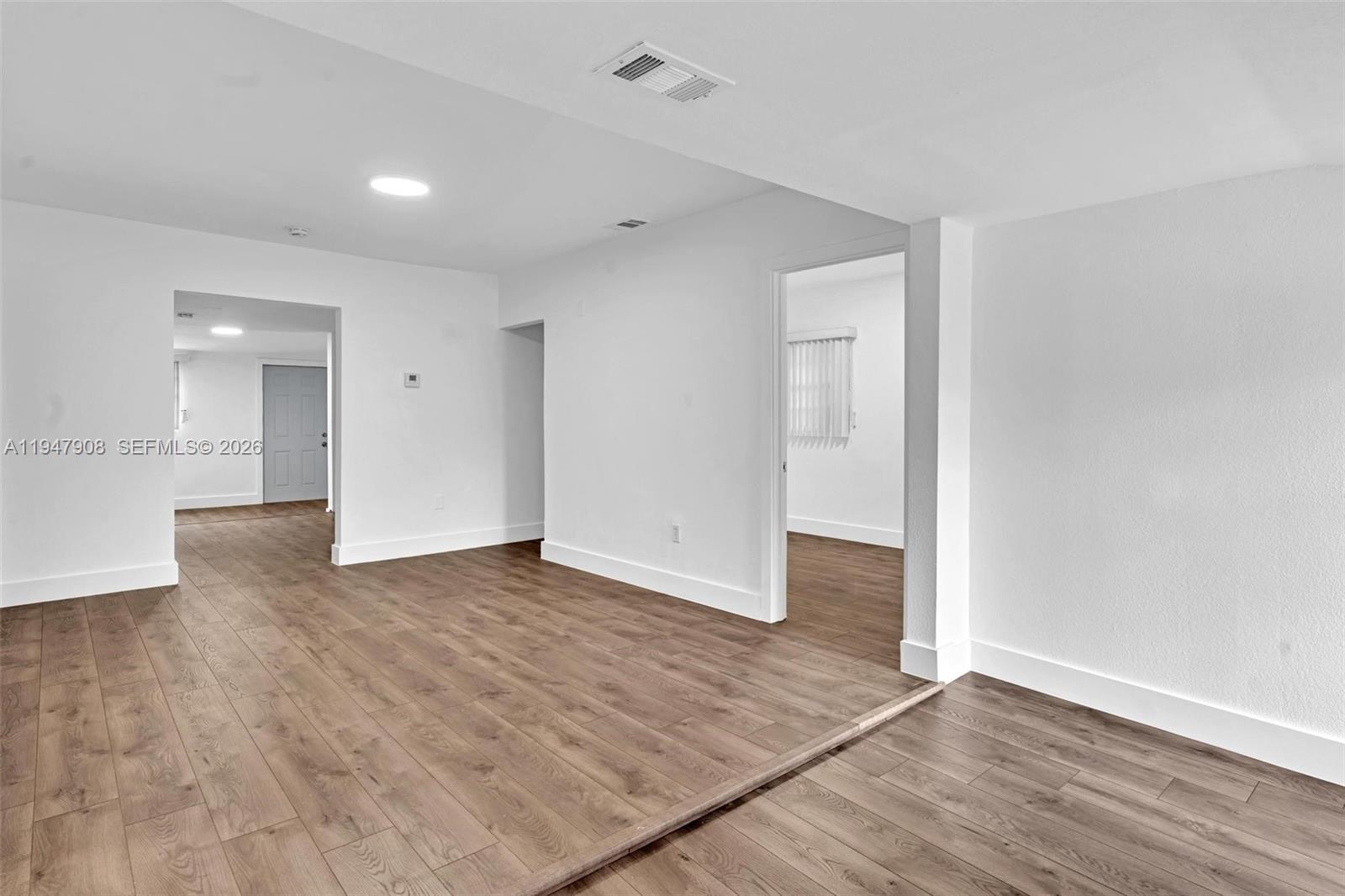 2636 Southwest 29th Court Miami, FL 33133 - Photo 4 of 33 a view of an empty room with wooden floor and a window