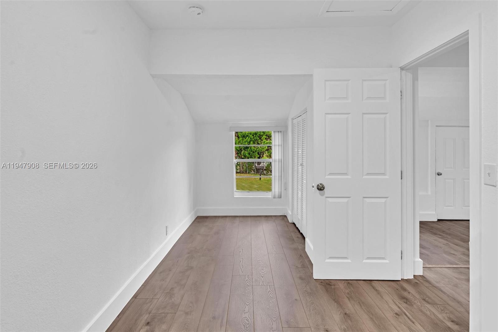 2636 Southwest 29th Court Miami, FL 33133 - Photo 7 of 33 a view of an empty room with wooden floor and a window