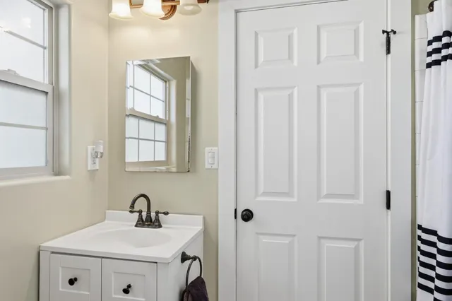 a bathroom with a sink a vanity and a window