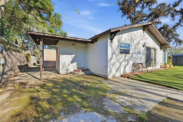 a view of a house with a patio and a yard