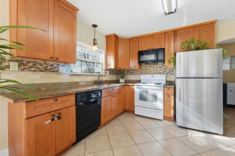 a kitchen with stainless steel appliances granite countertop a refrigerator sink and cabinets