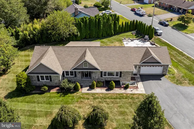 an aerial view of a house with swimming pool and a yard