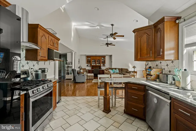 a kitchen with granite countertop lots of white cabinets and stainless steel appliances