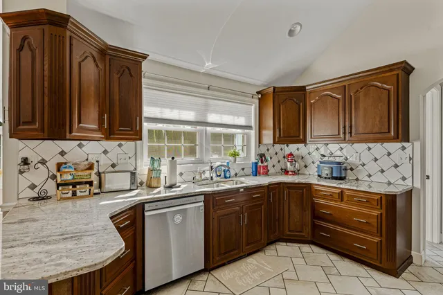 a kitchen with stainless steel appliances kitchen island granite countertop a refrigerator and cabinets