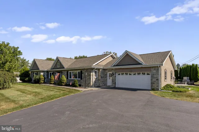 a front view of a house with a garden and yard