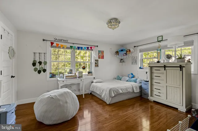 a bedroom with a bed and a flat tv screen on dresser