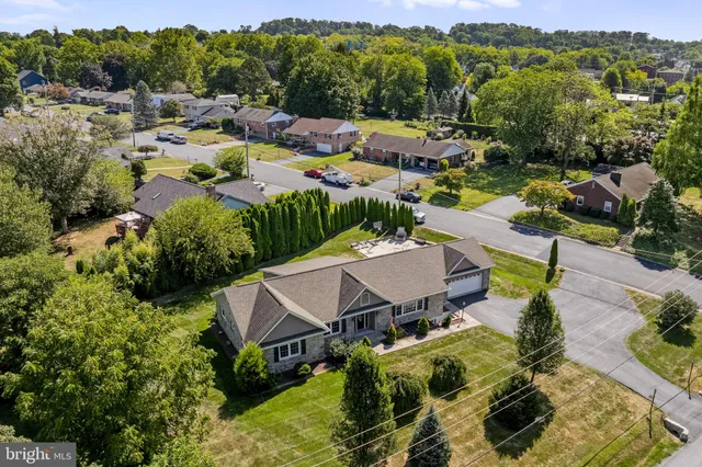 a view of a house with a big yard plants and large trees