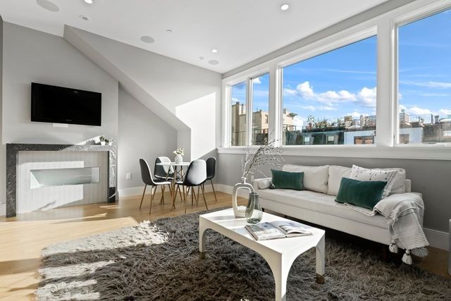 a living room with furniture a rug and a floor to ceiling window