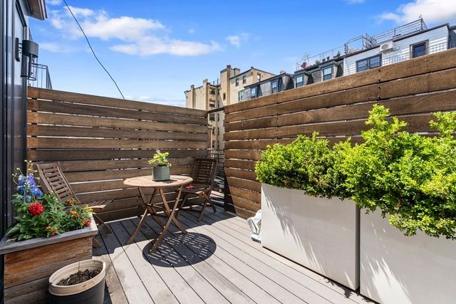 a view of a balcony with chairs and potted plants