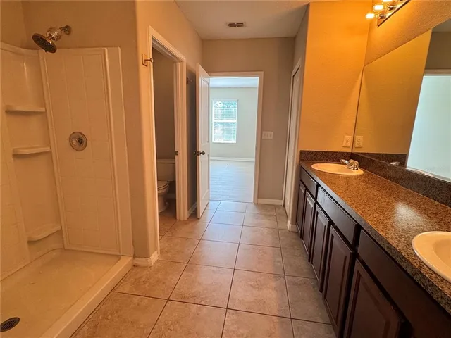a bathroom with a granite countertop sink a toilet and a shower