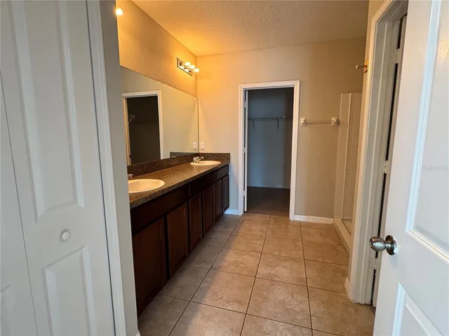 a bathroom with a granite countertop sink a mirror and a bathtub