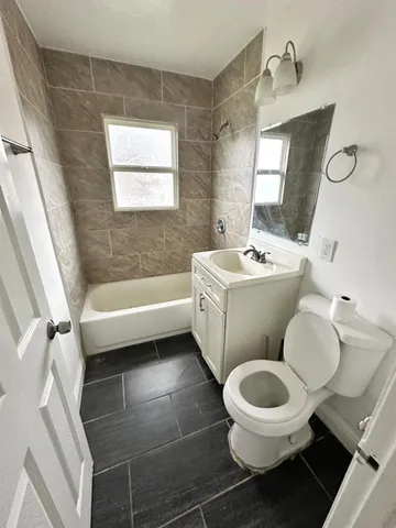 a bathroom with a toilet sink and mirror