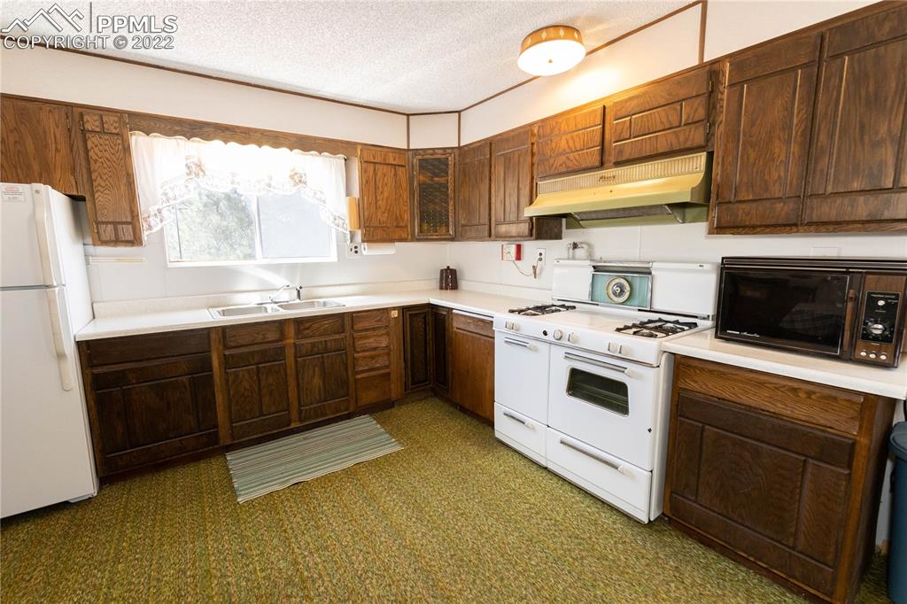 442 Due S Road Florissant, CO 80816 - Photo 30 of 43 a kitchen with a sink stove and cabinets