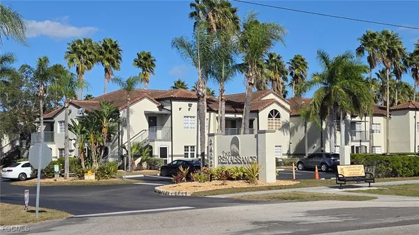 a front view of a building with palm trees