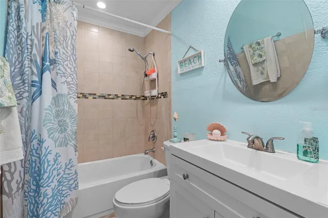 a bathroom with a toilet sink vanity tub and mirror