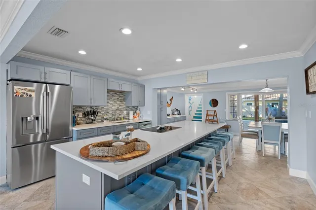 a kitchen with stainless steel appliances granite countertop a table chairs sink refrigerator and microwave