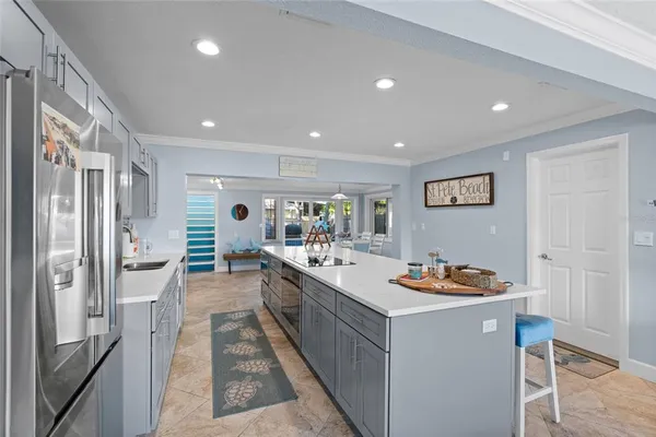 a large white dining hall with stainless steel appliances granite countertop a stove and a refrigerator
