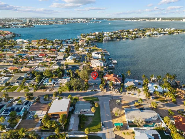 an aerial view of ocean and residential houses with outdoor space