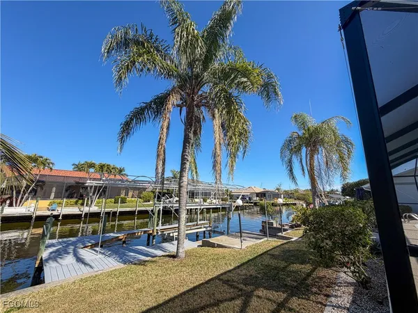 a view of a swimming pool with a lawn chairs under palm tree
