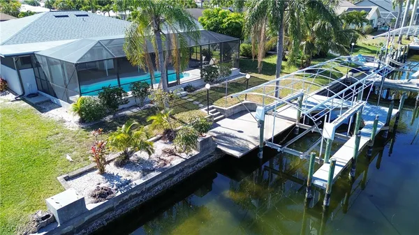 a view of swimming pool with lawn chairs and plants