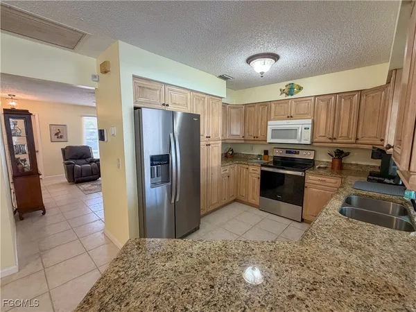 a kitchen with stainless steel appliances granite countertop a refrigerator sink and stove