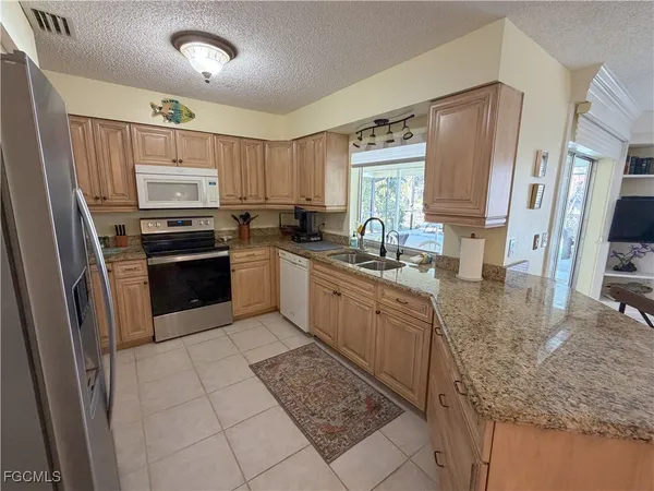 a kitchen with stainless steel appliances granite countertop a refrigerator sink and stove