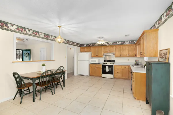 a kitchen with stainless steel appliances granite countertop a sink dishwasher stove top oven and refrigerator with wooden floor