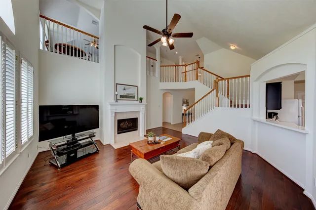 a living room with furniture a flat screen tv and a fireplace