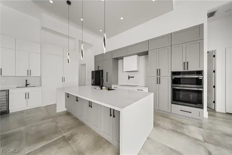 a large white kitchen with a large window