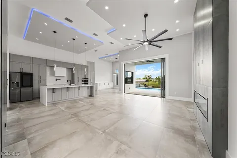 a view of an empty room and kitchen view