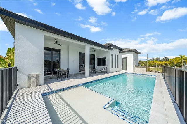 a swimming pool with outdoor seating and yard