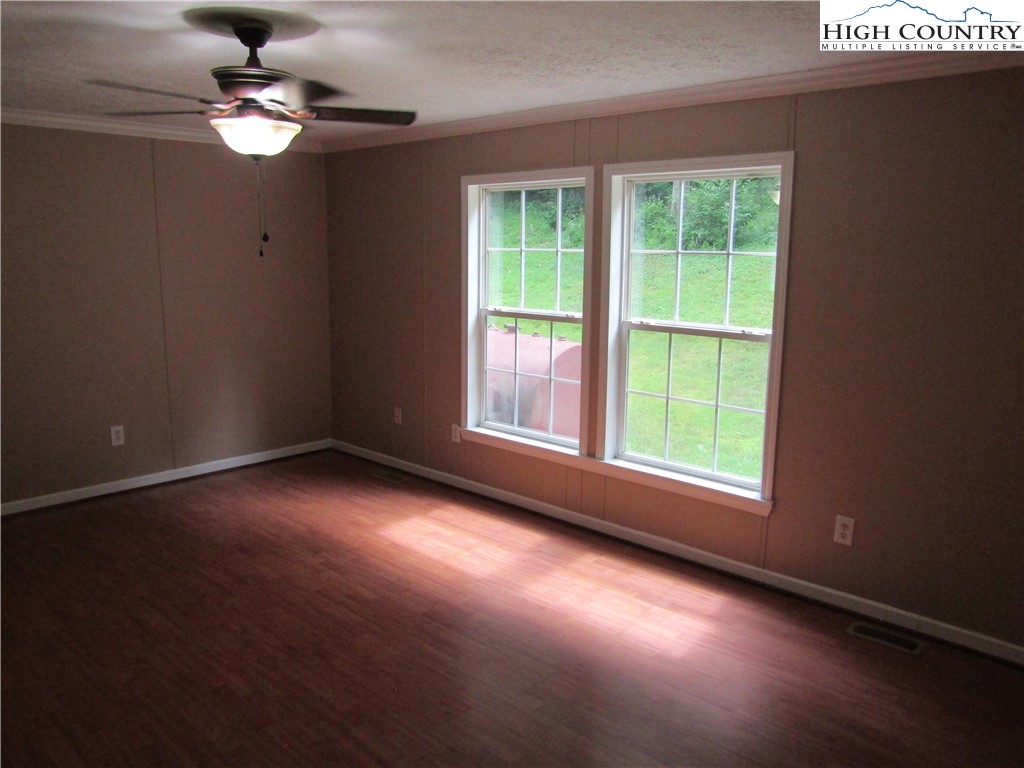 311 Walter Blevins Road Lansing, NC 28643 - Photo 16 of 22 a view of an empty room with chandelier fan and a window