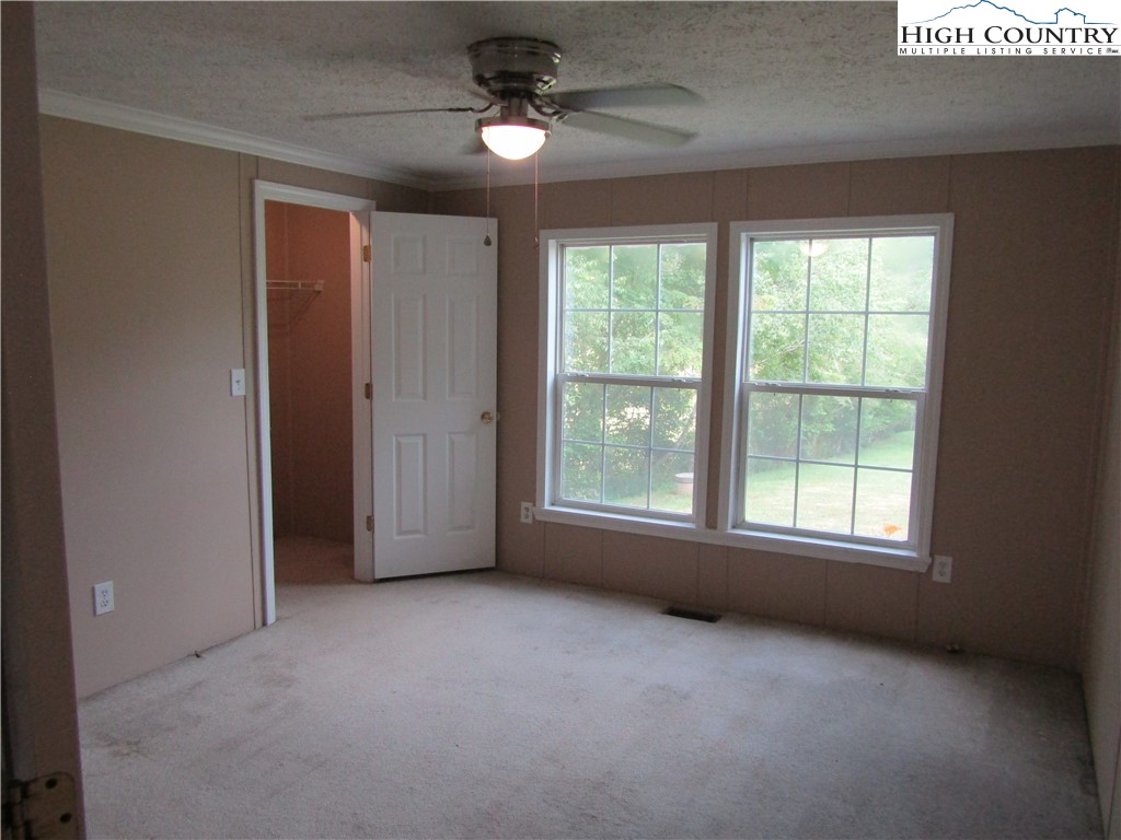 311 Walter Blevins Road Lansing, NC 28643 - Photo 19 of 22 an empty room with windows and fan