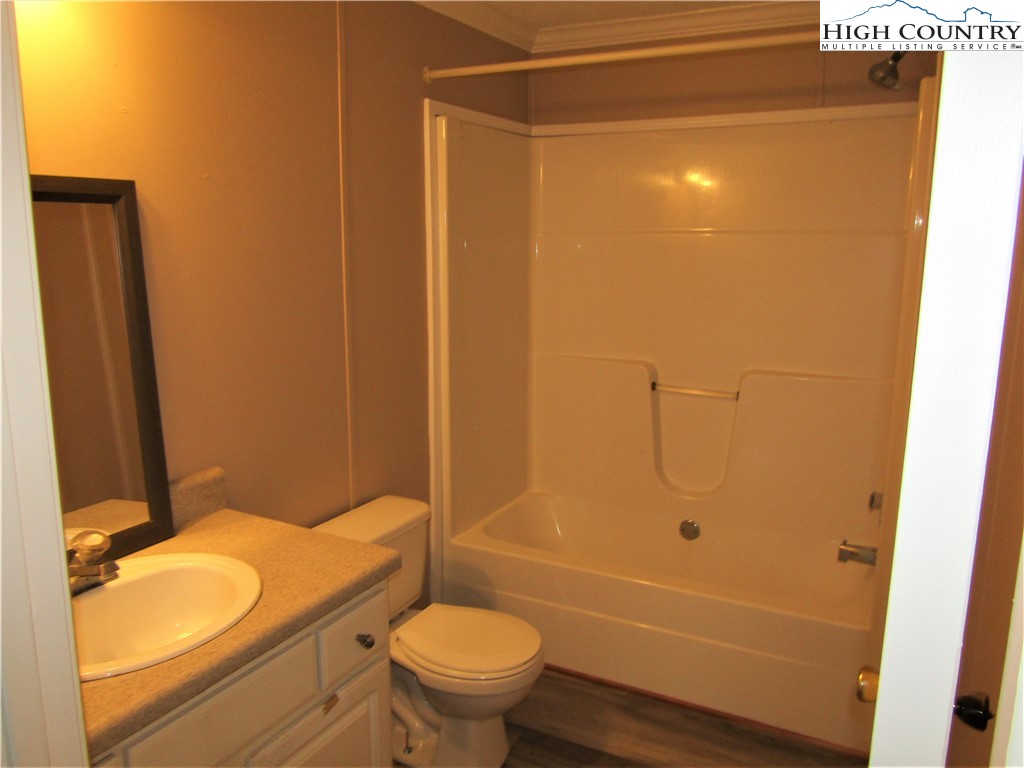 311 Walter Blevins Road Lansing, NC 28643 - Photo 20 of 22 a bathroom with a granite countertop bathtub shower sink vanity and toilet