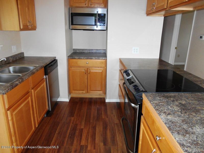 715 West 5th Street Rifle, CO 81650 - Photo 2 of 11 a kitchen with wooden cabinets and a stove top oven
