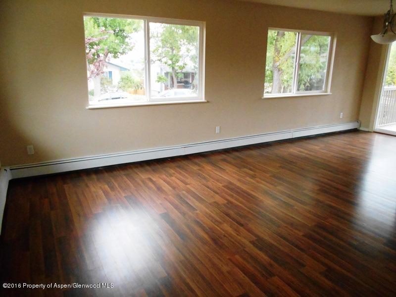 715 West 5th Street Rifle, CO 81650 - Photo 3 of 11 an empty room with wooden floor and windows