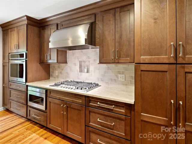 a kitchen with stainless steel appliances granite countertop a refrigerator stove and sink