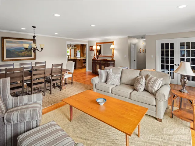 a living room with furniture kitchen view and a window