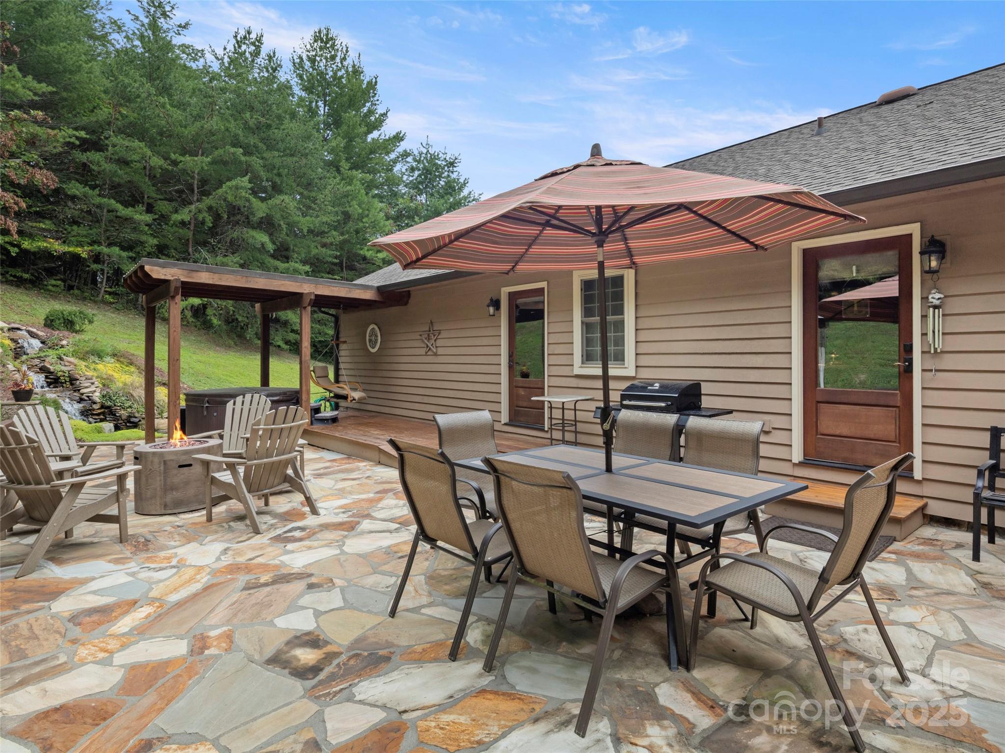 298 Lone Pine Road Alexander, NC 28701 - Photo 35 of 48 a view of a patio with table and chairs under an umbrella