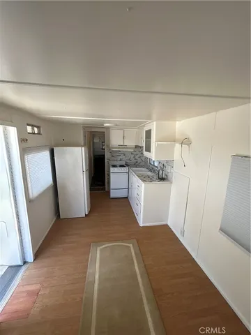 a view of a kitchen with refrigerator and white cabinets