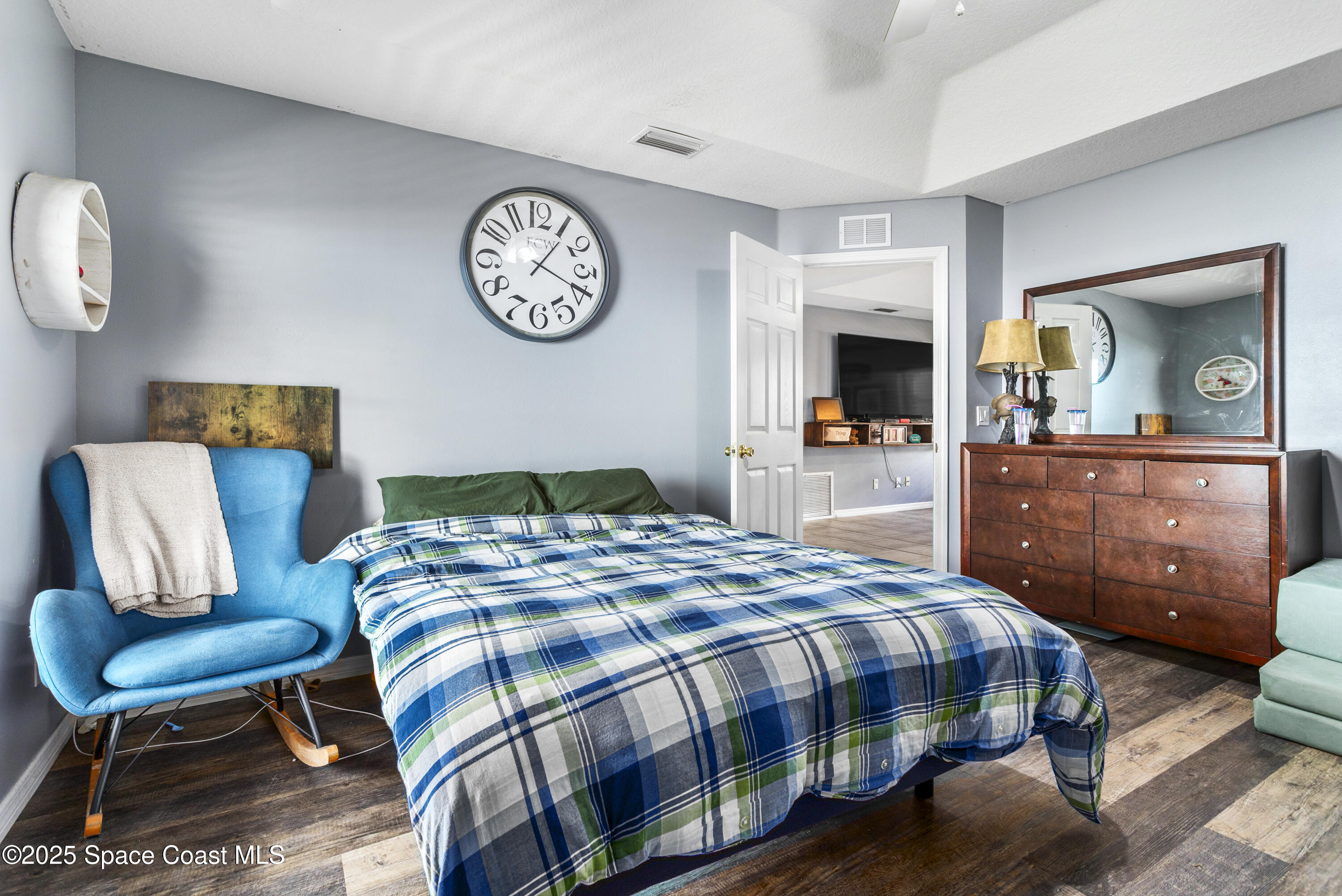 5964 Travis Street Mims, FL 32754 - Photo 15 of 45 a bedroom with a bed a mirror on dresser and a table